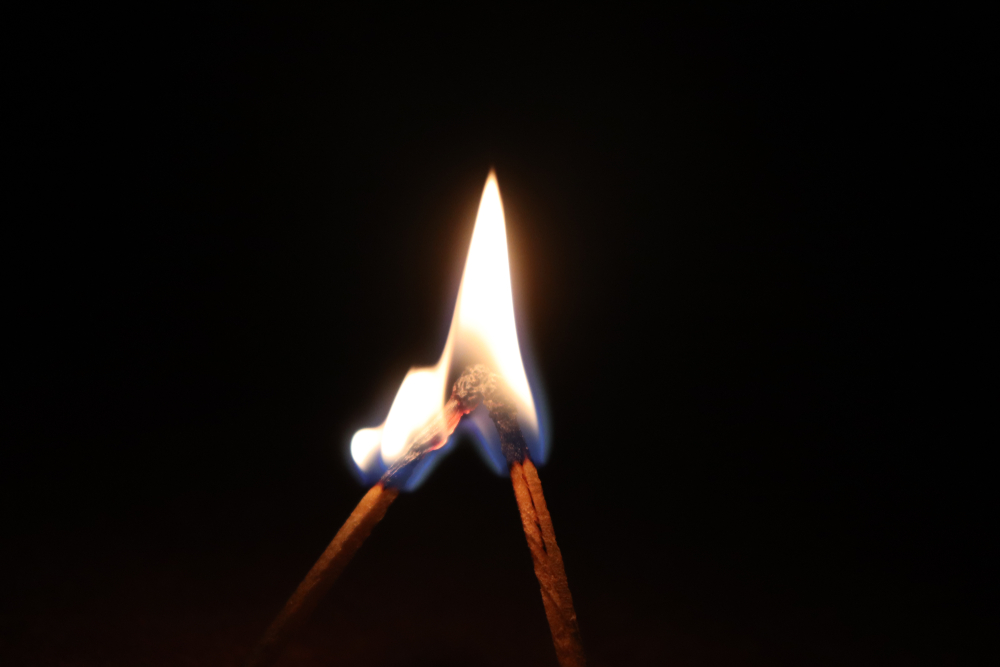 Two matches with flames merging together into one