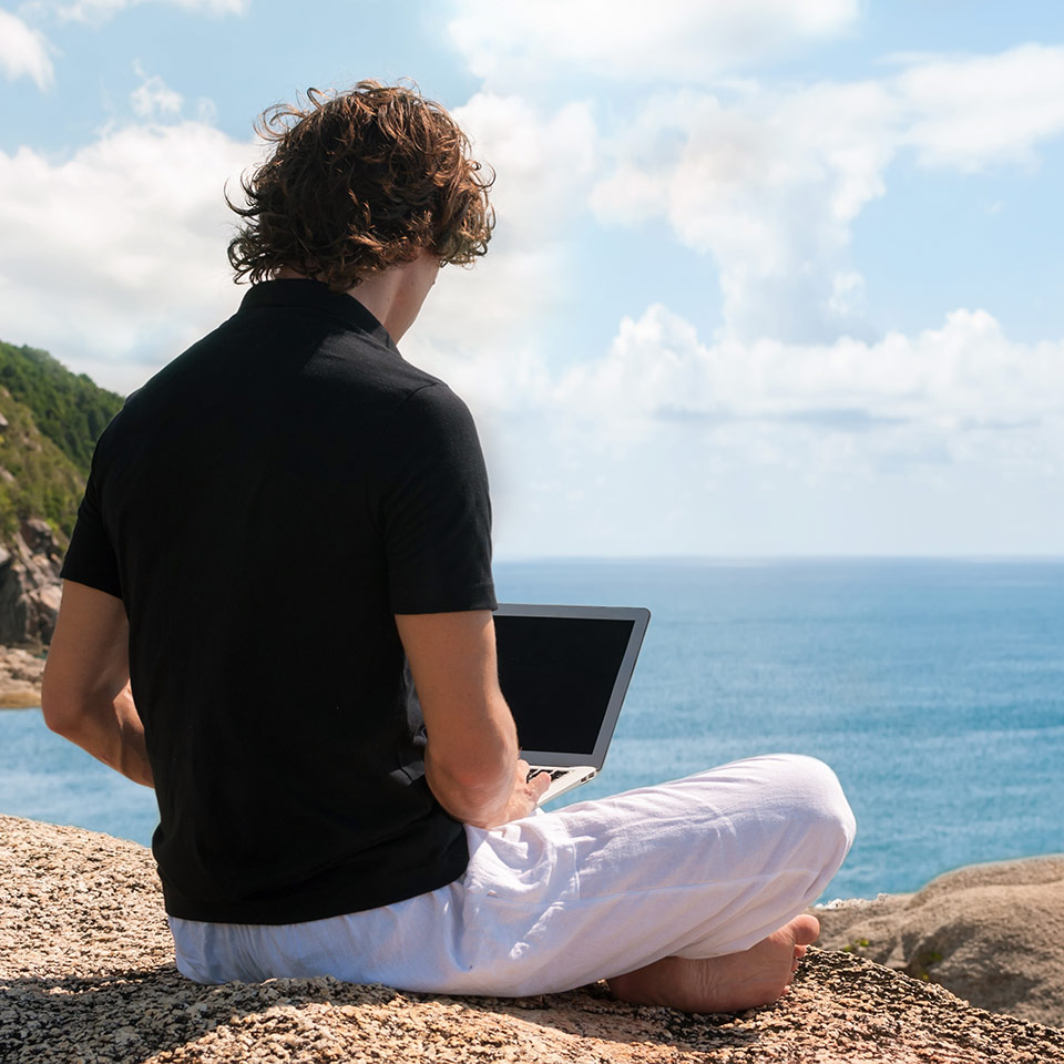 Man typing on his laptop while on his travels. 