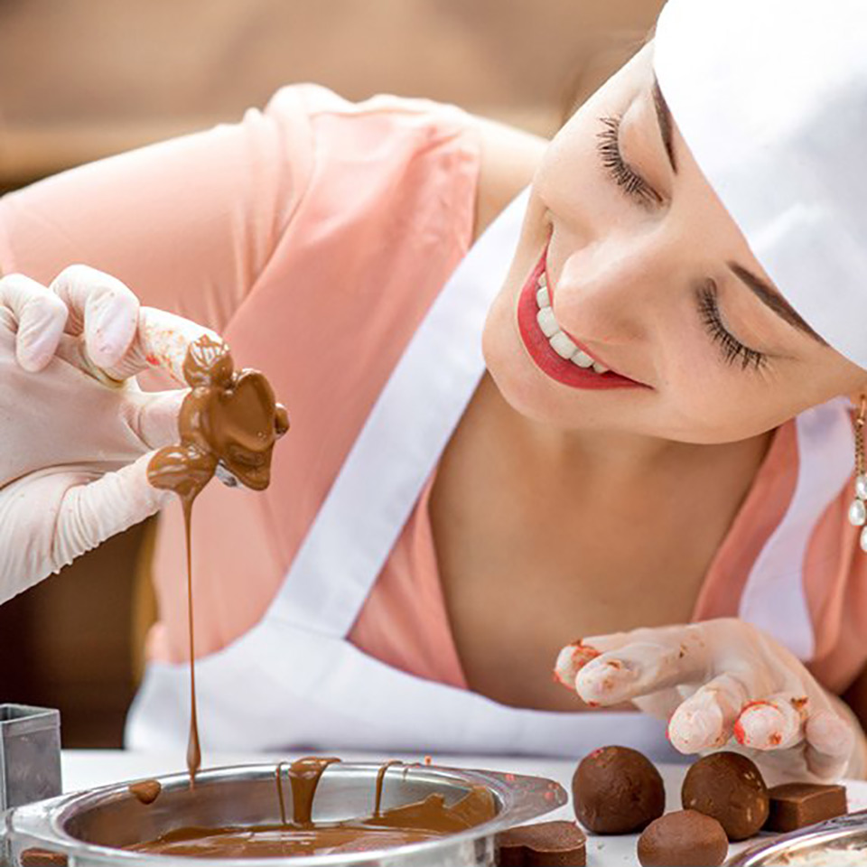 Woman smiling as she makes chocolate.