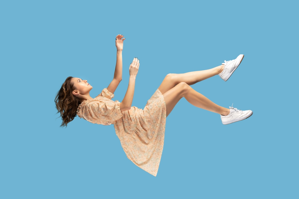 Woman falling against a blue background