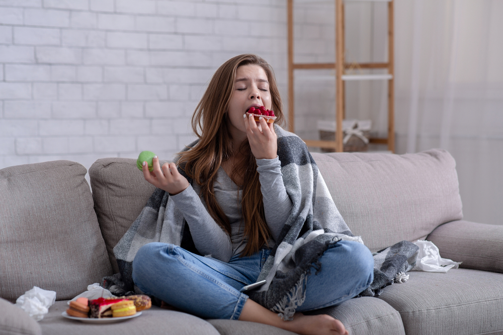 Young woman on a sofa comfort eating