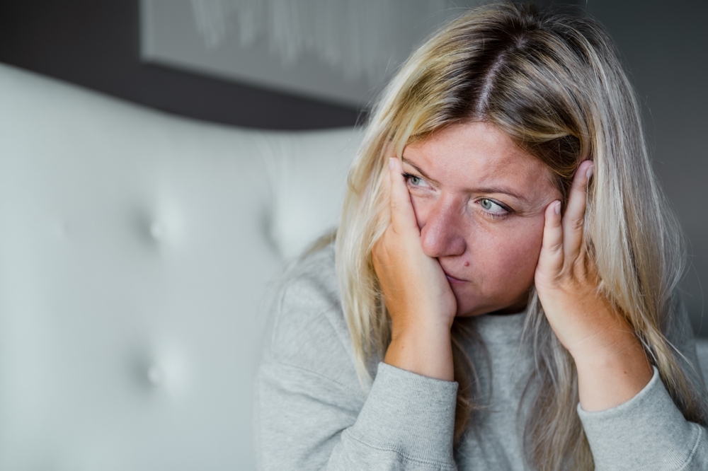 Woman looking anxious on a bed