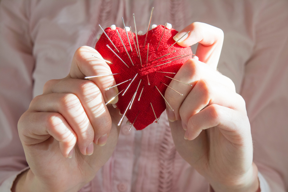 A heart cushion with pins sticking out of it