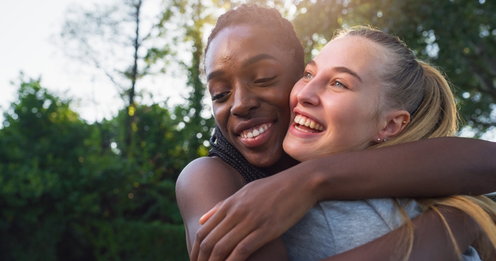 Two women smiling and hugging