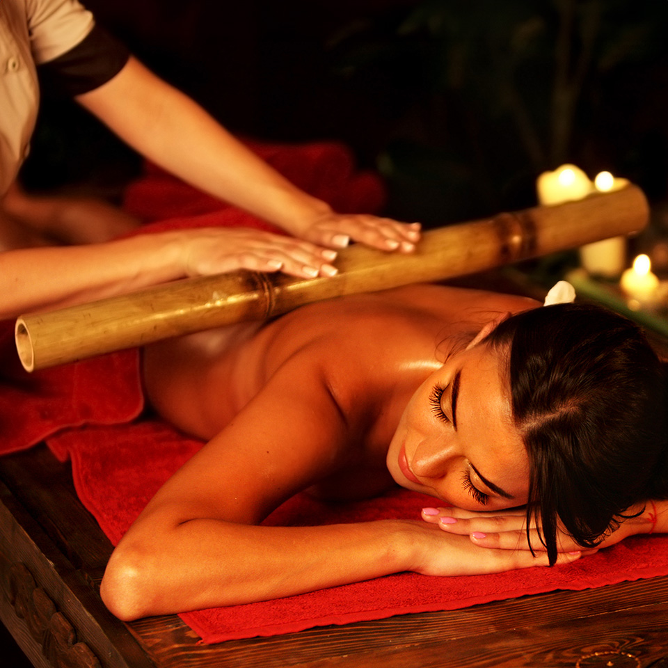 Woman receiving a bamboo massage at a spa.