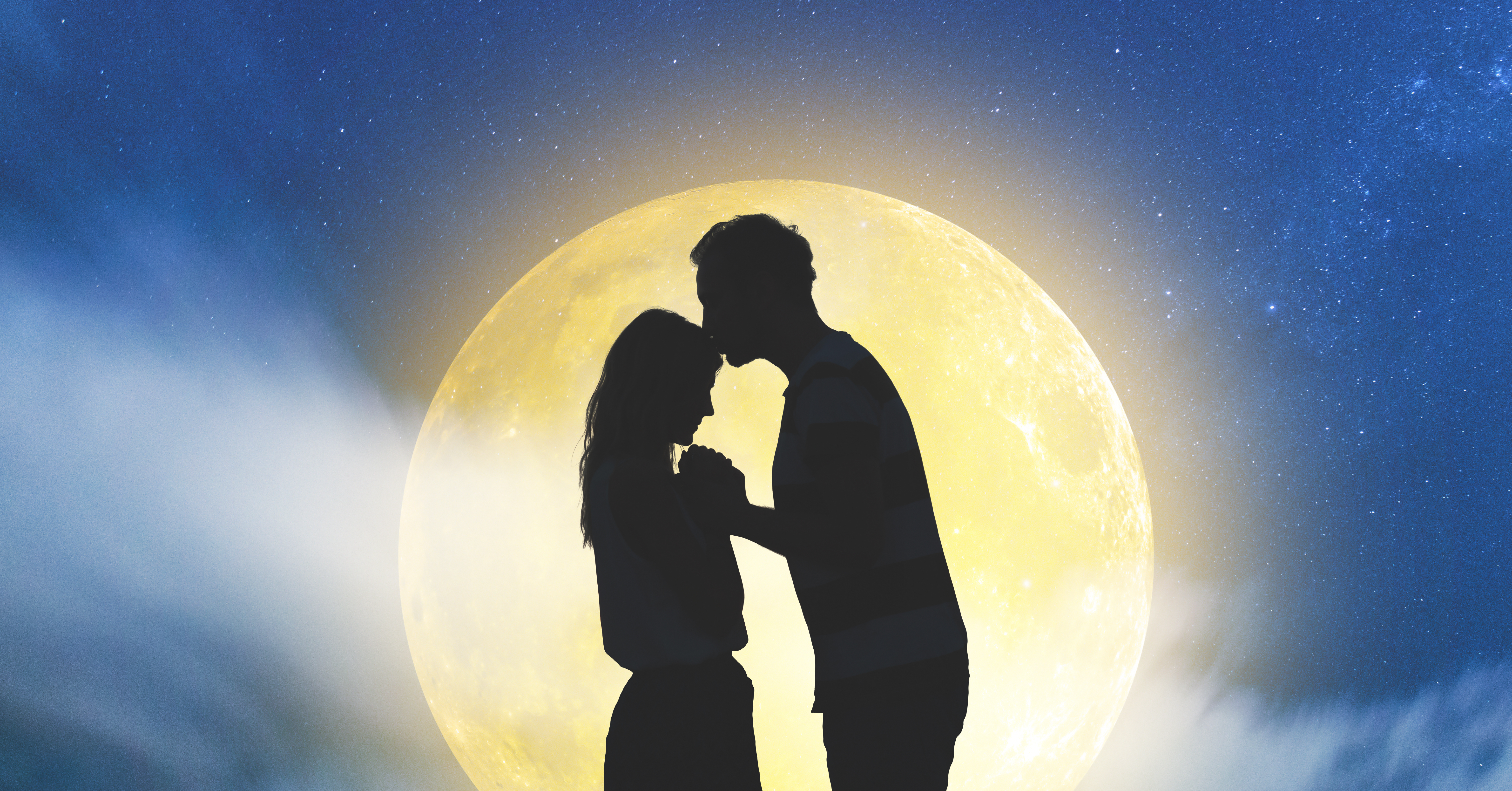 Silhouettes of a young couple under the starry sky with full moon