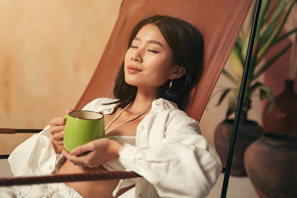 A woman relaxing with her eyes closed and a herbal tea