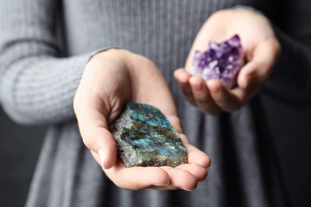 Someone holding a piece of Labradorite in the palm of their hand