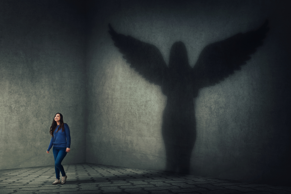 A woman with an angel shadow on the wall behind her